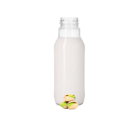 Nut milk in glass bottle and pistachios isolated on whiteの写真素材