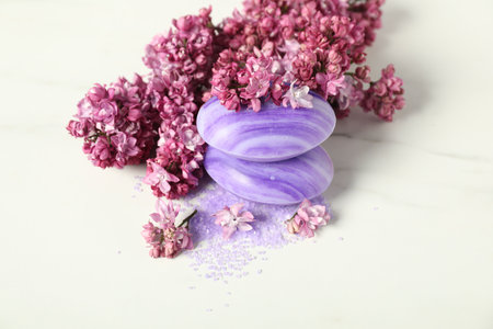 Soap bars, sea salt and lilac flowers on white table, closeupの写真素材