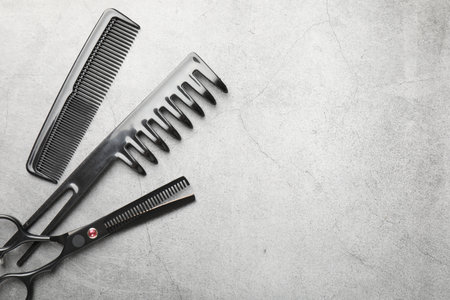 Different hairdresser's tools on grey table, flat lay. Space for textの写真素材