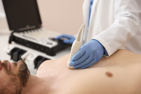 Sonographer conducting ultrasound examination of man's heart in clinic, closeup