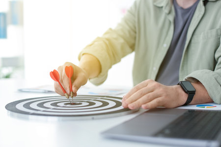 Man with dart aiming at dartboard indoors, closeupの写真素材