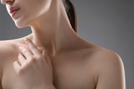 Woman with beautiful collarbones and neck on grey background, closeupの写真素材