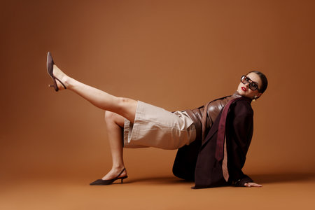 Young woman in stylish clothes on brown backgroundの写真素材