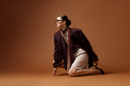 Young woman in stylish clothes on brown backgroundの写真素材