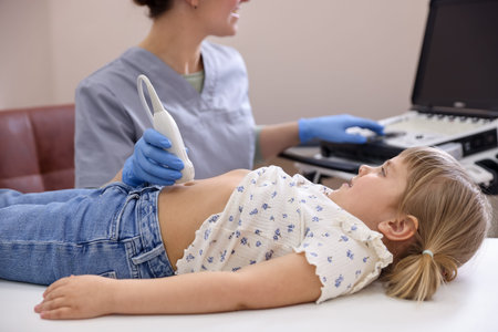 Sonographer conducting little girl's abdominal ultrasound examination in clinic, closeup