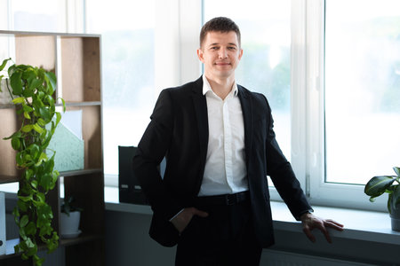 Portrait of handsome man near window indoors