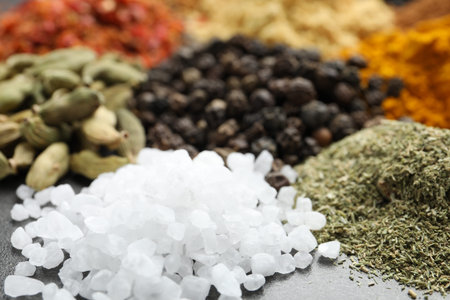 Many different spices on dark table, closeup