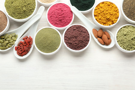 Different superfood powders on white wooden table, flat lay. Space for textの写真素材