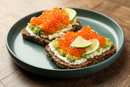 Delicious sandwiches with avocado, cream cheese and lime on wooden table, closeupの写真素材