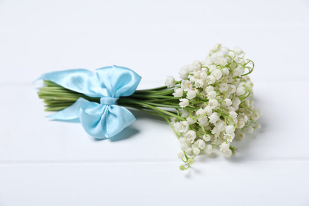 Bouquet of beautiful lily-of-the-valley flowers on white wooden background, closeupの写真素材