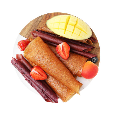 Fruit leather rolls, berries and mango isolated on white, top view