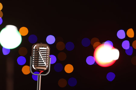 Vintage microphone on dark background with blurred lights, space for text. Musical equipmentの写真素材