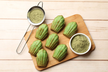 Tasty matcha madeleine cakes on light wooden table, top viewの写真素材