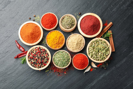 Different aromatic spices on black table, flat layの写真素材