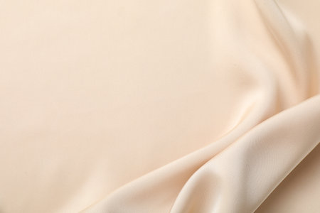 Crumpled beige silk fabric as background, top view. Space for textの写真素材