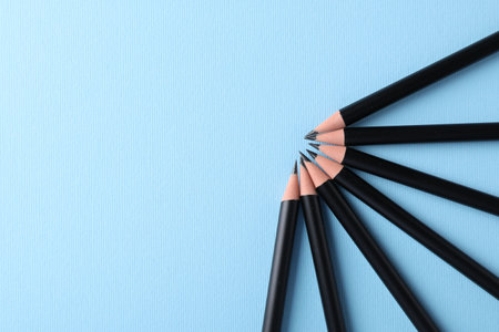 Many sharp graphite pencils on light blue background, flat lay. Space for textの写真素材