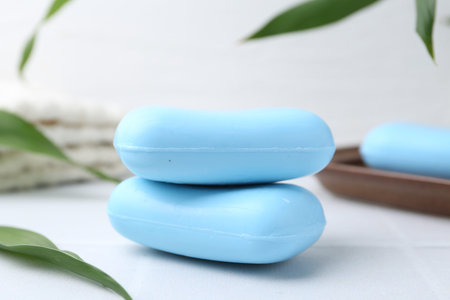 Soap bars with foam on white table, closeup