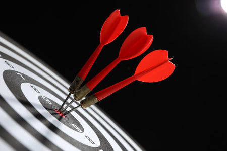 Targeting. Dart board with arrows on black background, closeupの写真素材