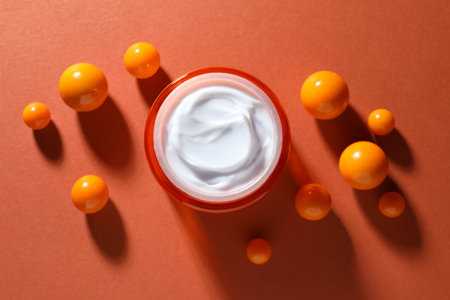 Jar of moisturizing body cream and balls on orange background, flat layの写真素材