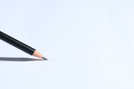 Sharp graphite pencil on white background, closeup. Space for textの写真素材