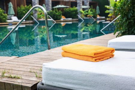 Sun loungers near outdoor swimming pool at luxury resortの写真素材