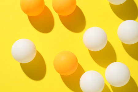 Ping pong balls on yellow background, flat layの写真素材