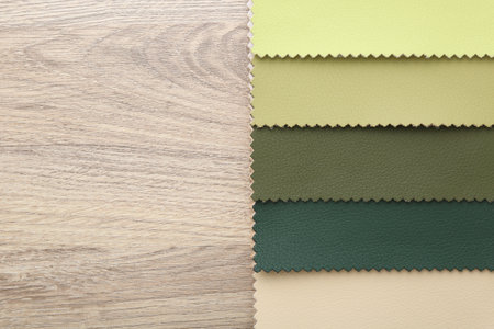Samples of different fabrics on wooden table, top view. Space for textの写真素材