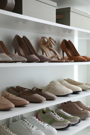 Different footwear on shelves indoors, closeup. Shoe storageの写真素材
