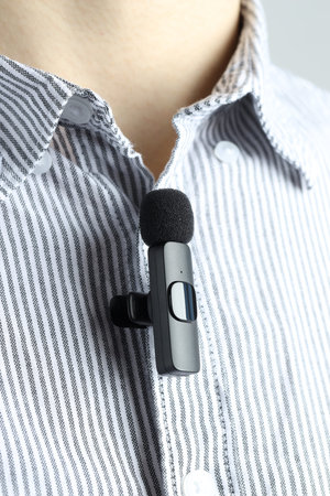 Man with lavalier microphone attached to his shirt, closeup