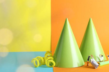 Beautiful party hats, streamers and blower on color background, space for textの写真素材