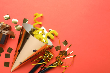 Beautiful party hat and other festive decor on red background, flat lay. Space for textの写真素材