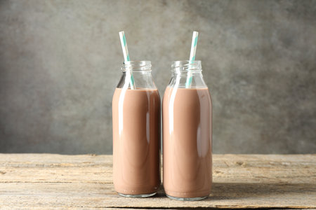Tasty chocolate milk in glass bottles on wooden tableの写真素材