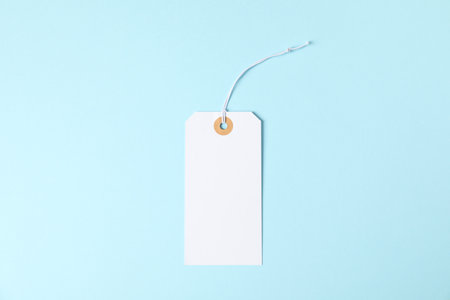 One blank tag with string on light blue background, top viewの写真素材