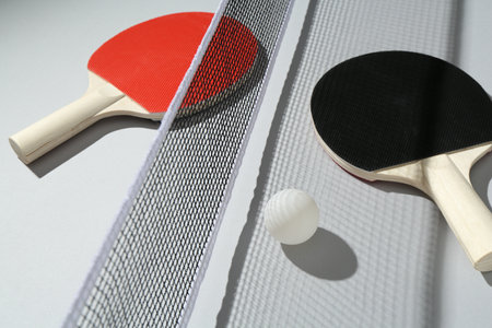 Ping pong rackets, ball and net on light backgroundの写真素材