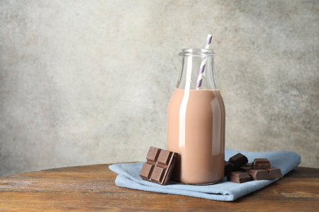 Chocolate milk in glass bottle and ingredient on wooden table, space for textの写真素材