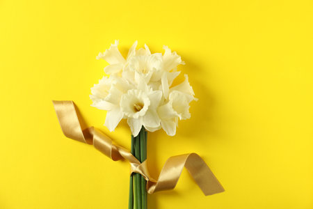 Bunch of beautiful daffodils on yellow background, top viewの写真素材