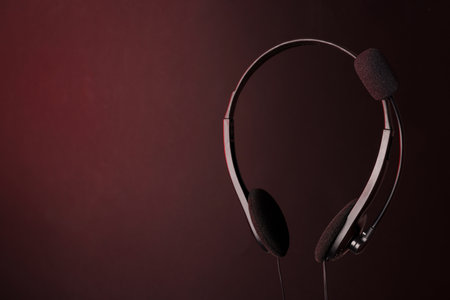 Headset with microphone in air on dark background, space for textの写真素材