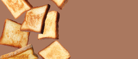 Pieces of toasted bread falling on brown background. Banner design with space for text