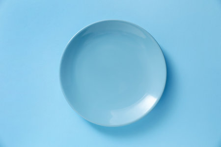 One stylish plate on light blue background, top viewの写真素材