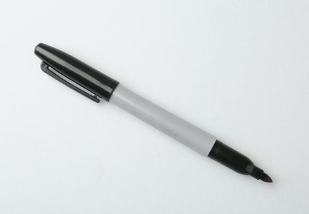 One black marker on light background, top view. Space for text