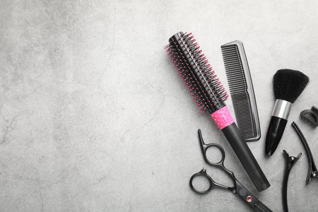 Different hairdresser's tools on grey table, flat lay. Space for textの写真素材
