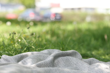 Light grey blanket for picnic on green grass outdoors, closeupの写真素材