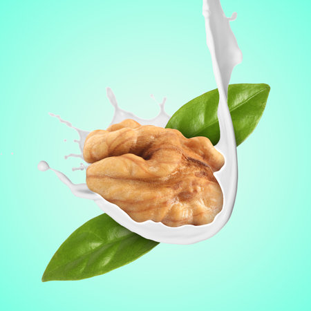 Nut milk splashing with walnut and green leaves in air on turquoise gradient background
