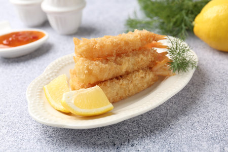 Tasty tempura shrimps, lemon and dill on grey textured table, closeup