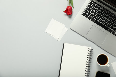 Flat lay composition with stationery, coffee and flower on light grey background. Space for textの写真素材