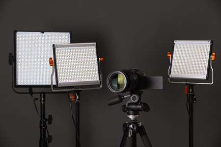 Professional lighting equipment and camera on grey background
