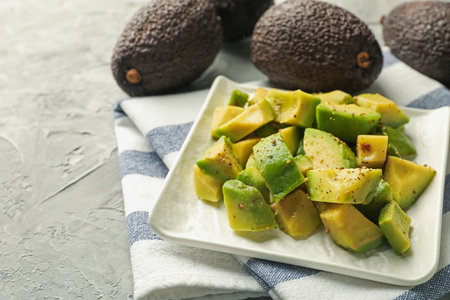Tasty cut avocados with dressing on grey textured table, closeupの写真素材