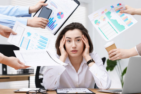 Woman overwhelmed by different requests from colleagues at desk in office