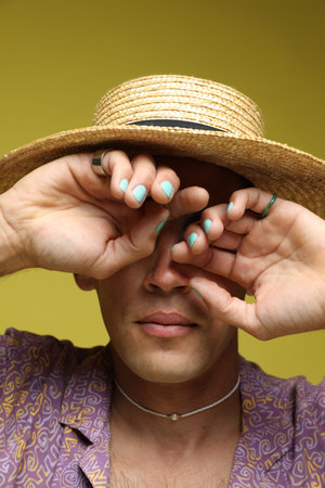 Fashionable portrait of handsome man in stylish outfit on olive background, closeup