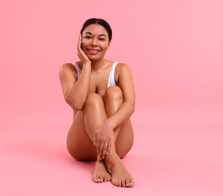 Woman in underwear with smooth skin after epilation procedure on pink background, space for textの写真素材